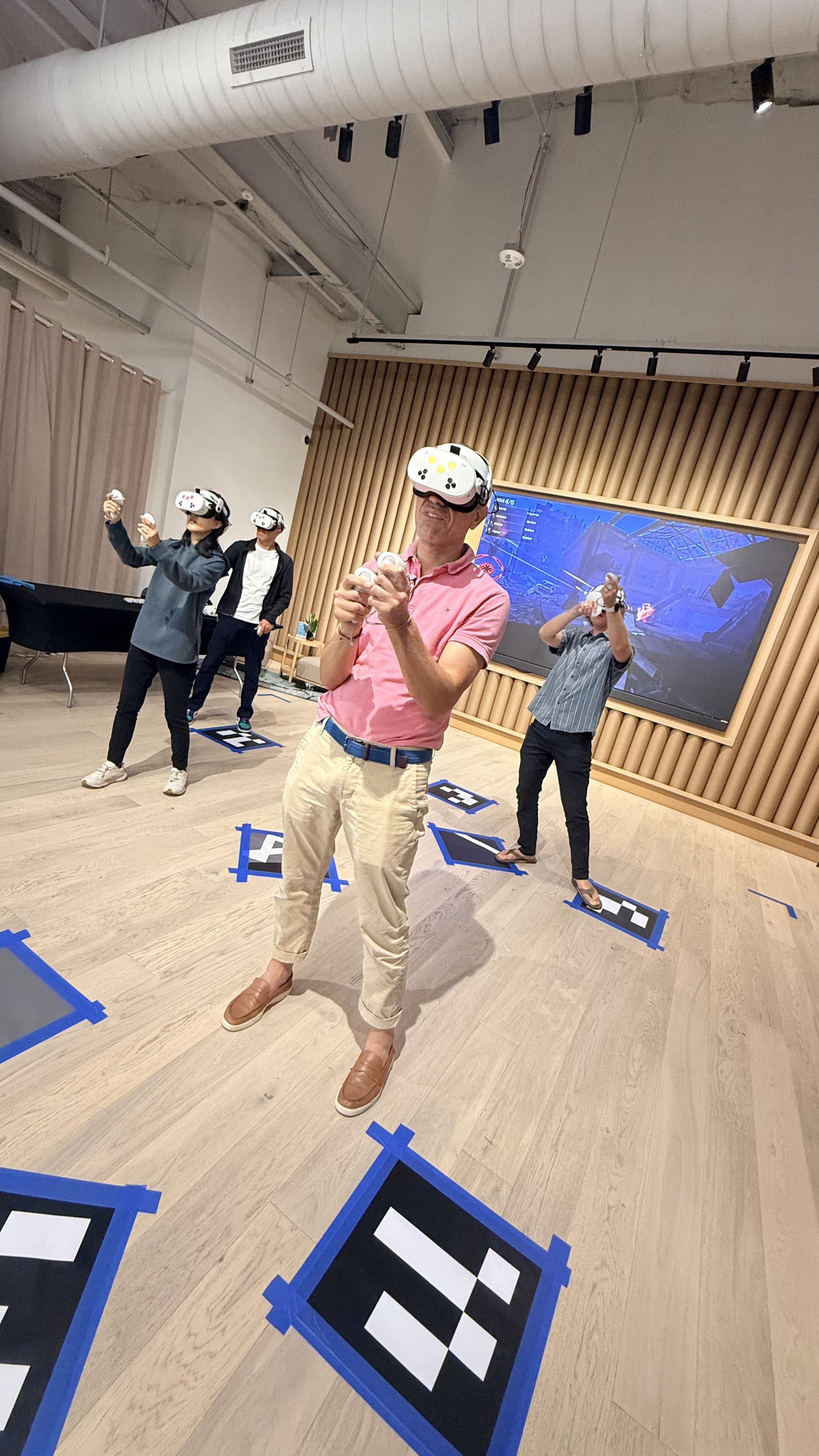 Four players in VR headsets playing together in an office event space